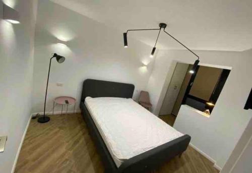 um quarto com uma cama e um candeeiro em Enescu Flat em Suceava
