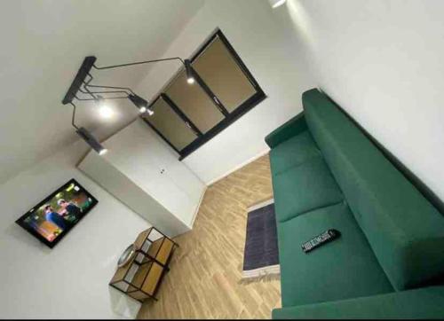 a living room with a green couch and a television at Enescu Flat in Suceava
