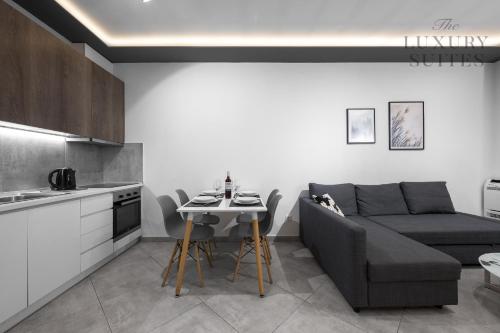 a kitchen and a living room with a couch and a table at Adelle Apartments, The Luxury Suites in Thessaloniki