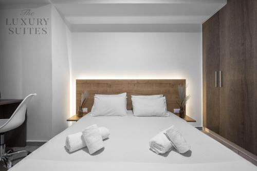 a bedroom with a large white bed with two pillows at Adelle Apartments, The Luxury Suites in Thessaloniki