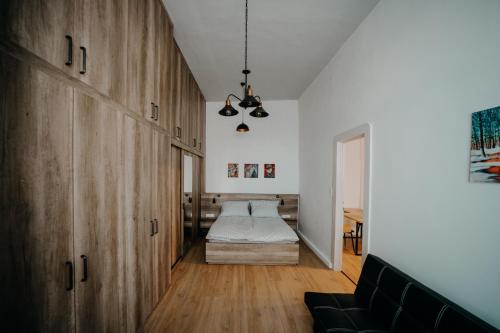 a bedroom with a bed in the corner of a room at Volenter Lux Apartment Zero in Baja