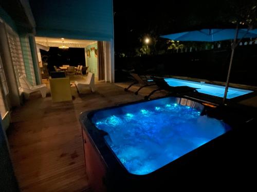 a hot tub in the middle of a patio at night at Villa Colibri in Les Trois-Îlets