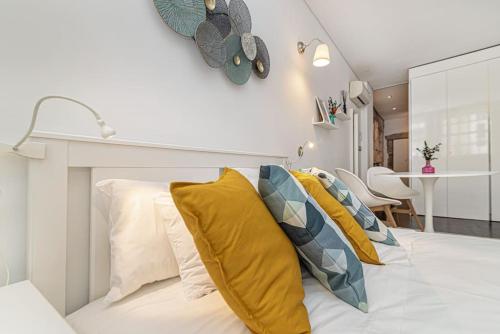 1 dormitorio con cama blanca y almohadas amarillas en Taylors apartment by Innkeeper en Vila Nova de Gaia