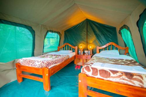 a bedroom with two beds in a tent at Engiri Game Lodge and Campsite in Katunguru