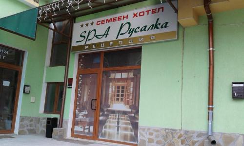 a store with a sign on the front of a building at Семеен Хотел Русалка in Svishtov
