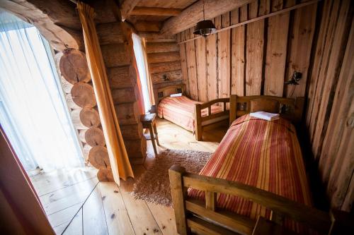 Habitación con 2 camas en una cabaña de madera en Greete Motel, en Soontaga