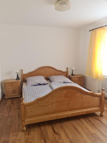 Cama de madera en un dormitorio con suelo de madera en Ferienwohnung Missen-Wilhams en Missen-Wilhams