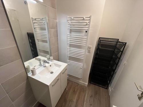 La salle de bains est pourvue d'un lavabo blanc et d'un miroir. dans l'établissement T2 Hyper Centre, proche port, plage et gare, au Pouliguen