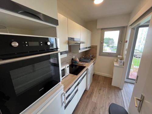 Il comprend une cuisine équipée d'un grand four micro-ondes et d'une cuisinière. dans l'établissement T2 Hyper Centre, proche port, plage et gare, au Pouliguen