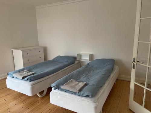 ein Schlafzimmer mit 2 Betten und einer Kommode darin in der Unterkunft Central lejlighed i Herning in Herning