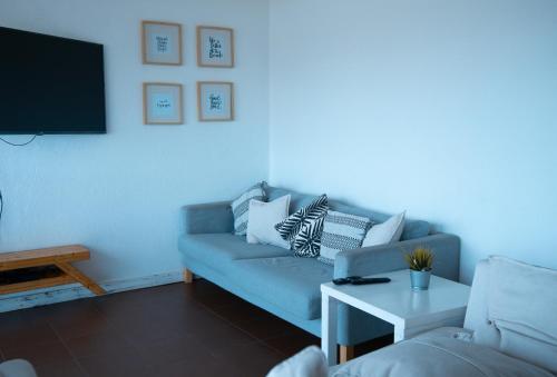 a living room with a couch and a tv at Wax Hostel in Faro