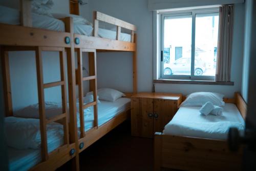 a bedroom with two bunk beds and a window at Wax Hostel in Faro