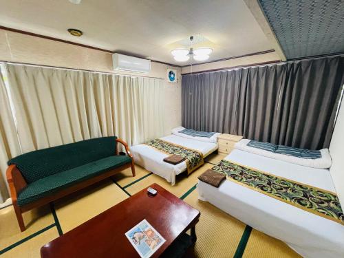 高島市にあるShiga Biwa Lake Shanshui Houseのベッド2台とソファが備わるホテルルームです。