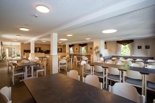 a dining room with tables and white chairs at Sportschule Werdau in Werdau
