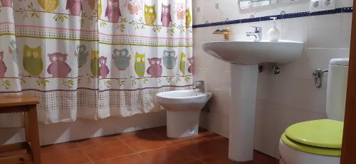 a bathroom with a sink and a toilet and a shower curtain at El Portal in Letur
