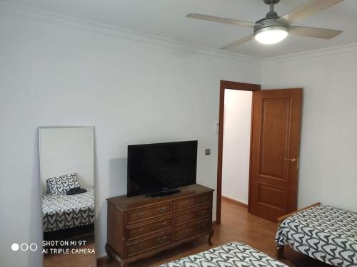 a living room with a flat screen tv on a dresser at Casa Rosas in Vélez-Málaga