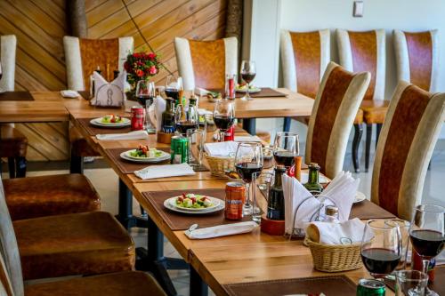 una mesa larga con copas de vino y platos de comida en Ecohotel Talca, en Talca