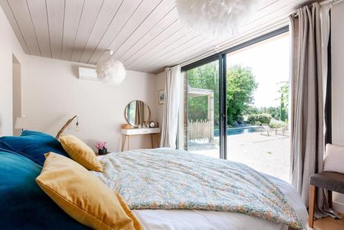 ein Schlafzimmer mit einem Bett und einem großen Fenster in der Unterkunft Un loft à la campagne Luberon in Puget