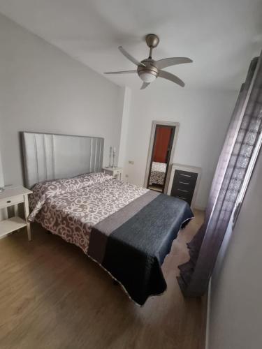 una camera con letto e ventilatore a soffitto di BEAUTIFUL PENTHOUSE SOLARIUM IN BOLICHES BEACH a Fuengirola