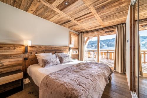 a bedroom with a bed and a large window at Chalet Floquet de Neu Les Gets- BY EMERALD STAY in Les Gets