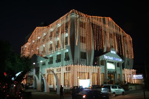 un gran edificio cubierto de luces de Navidad por la noche en Hotel The Grand Chandiram, en Kota