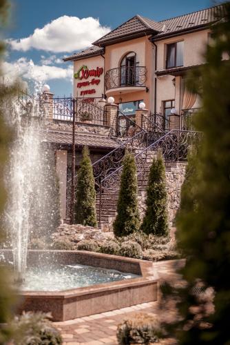 a water fountain in front of a building at Готель Хутір in Malyye Khutora