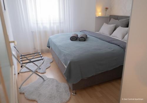 Un dormitorio con una cama con dos zapatos. en Central Apartman, Belváros Lakás, en Kecskemét