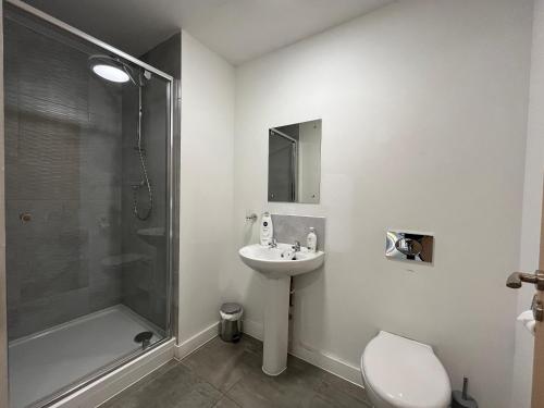 a bathroom with a toilet and a sink and a shower at Modern 1 Bedroom Apartment Central Manchester in Manchester
