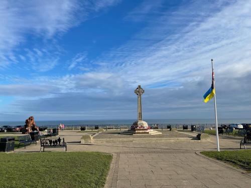 a flag and a clock tower in a park at A lovely 3 bedroom family house! in Seaham