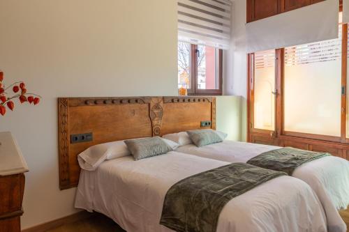 1 Schlafzimmer mit 2 Betten und einem Fenster in der Unterkunft Apartamento turístico 'Botica Moro' in Boñar