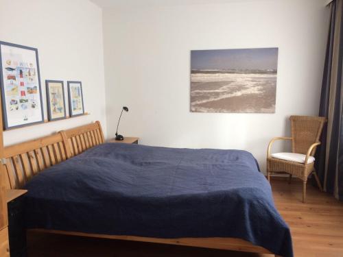 een slaapkamer met een bed met een blauwe deken bij Melissa in Westerland