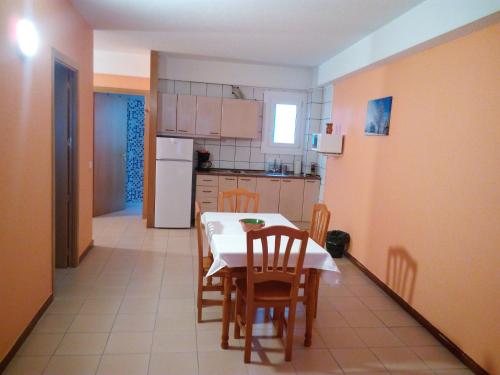 uma cozinha com mesa e cadeiras e uma cozinha com electrodomésticos brancos em Apartaments Els Avets em Pas de la Casa