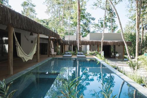 a villa with a swimming pool and a house at CASA SUKHA Hotel in Trancoso