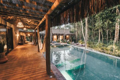 a house with a swimming pool on a wooden deck at CASA SUKHA Hotel in Trancoso