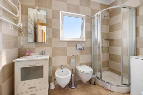 a bathroom with a toilet and a shower and a sink at Lagos Beach Pool Villa in Lagos