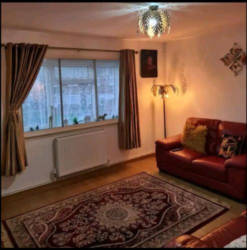 sala de estar con sofá y ventana en Babus International, en Cranford