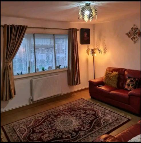 a living room with a couch and a window at Babus International in Cranford