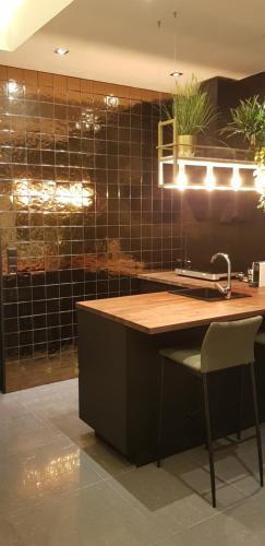 een keuken met een wastafel en een aanrecht met een stoel bij Noordersluis Studio's in Lelystad