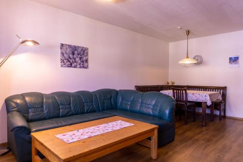 a living room with a couch and a table at Gästehaus Wötzer und Landhaus Stocka in Grän