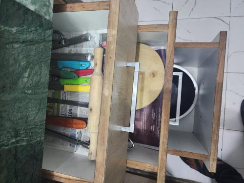a wooden cabinet with a bunch of books in it at Homlee-Best Value-1BHK-Dilshad Metro-Kitchen in New Delhi