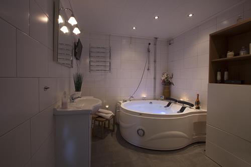 a bathroom with a large tub and a sink at Prinsgården B&B rum stugor in Mora