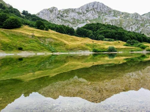 a reflection of a mountain in a body of water at Bosnian Villa in Hadžići