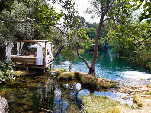 a bridge over a river with people sitting on it at Bosnian Villa in Hadžići