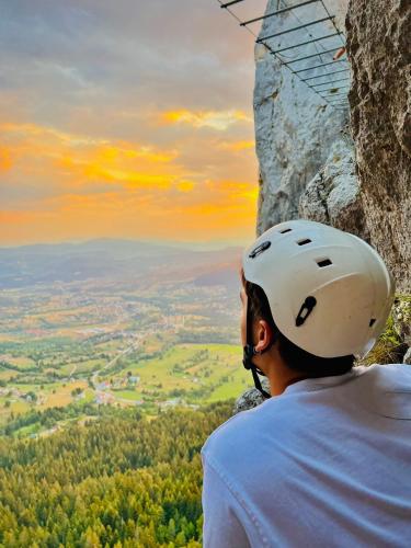 a man in a helmet is looking at a view from a mountain at Bosnian Villa in Hadžići