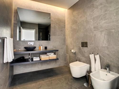 a bathroom with a sink and a toilet and a mirror at Francelho 2 Aparment by MHM in Ribeira Brava