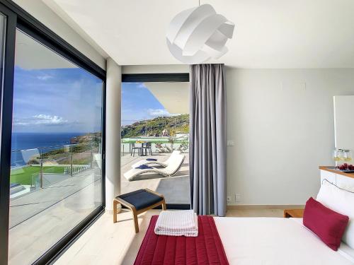 een slaapkamer met een bed en uitzicht op de oceaan bij Francelho 2 Aparment by MHM in Ribeira Brava