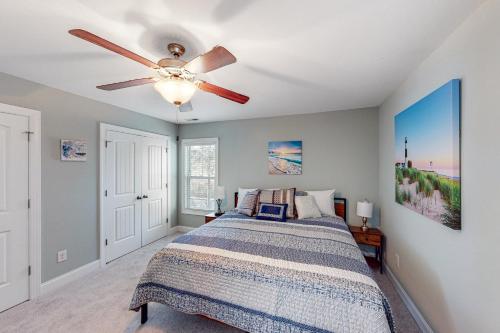 a bedroom with a bed and a ceiling fan at Oak Island Oasis in Oak Island
