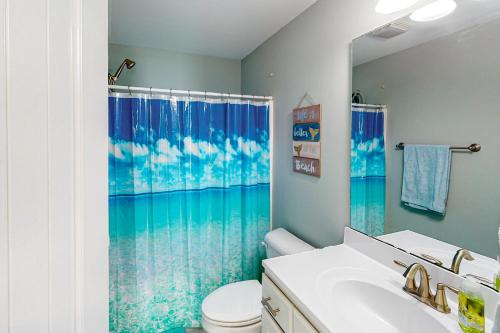 a bathroom with a toilet and a shower curtain at Oak Island Oasis in Oak Island