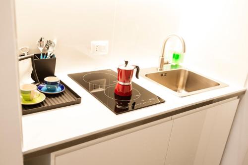 eine Küche mit einer Spüle und einer Kaffeemaschine auf der Theke in der Unterkunft La Hara Apartments in Neapel