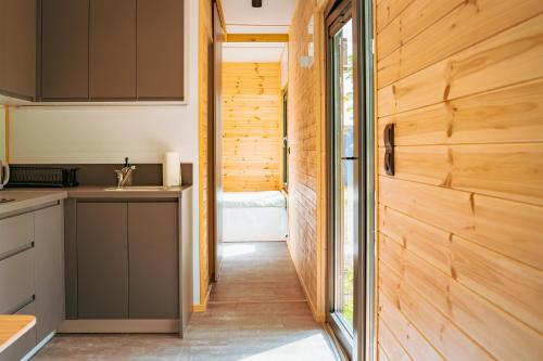 a kitchen with wood paneling and a hallway at Arche Siedlisko Augustynka 39 in Augustynka